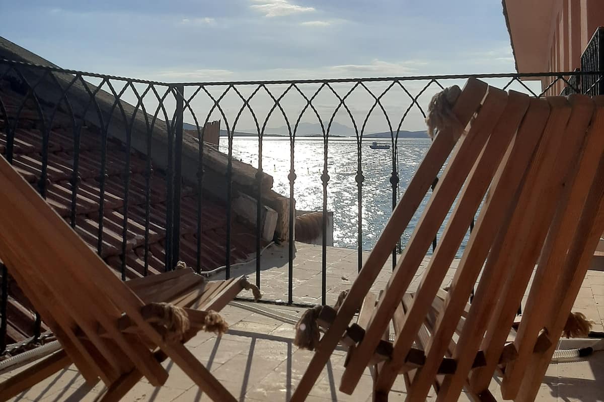 A balcony with a metal railing overlooking a body of water.
