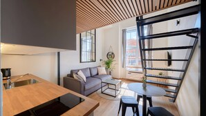A modern kitchen with a wooden countertop, a built-in dishwasher, and a sink. - Queen Barbora Central Lofts (Kaunas)