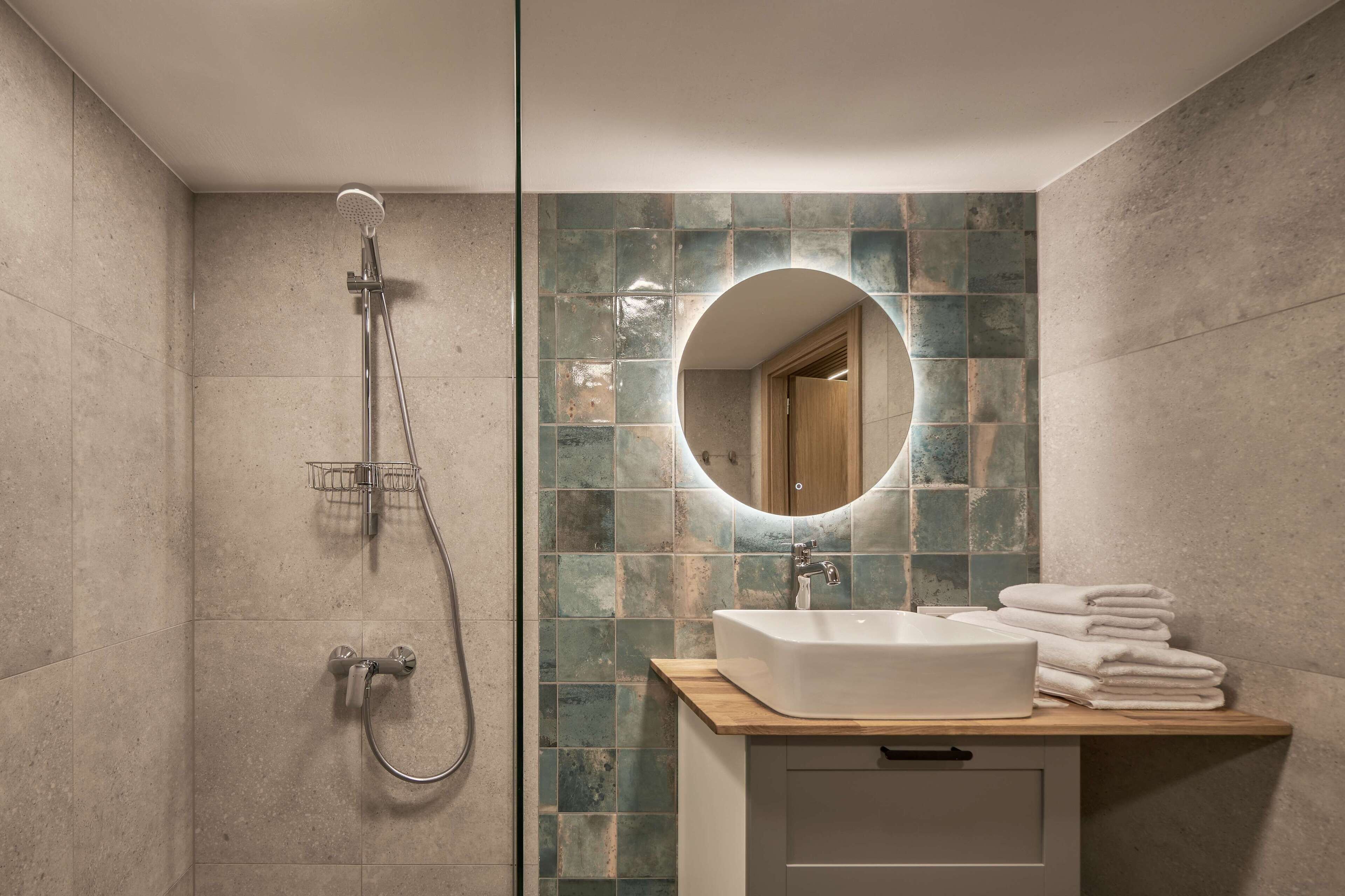 Un baño con ducha, lavabo y espejo.