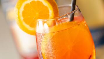 Primer plano de un vaso con una bebida y una rodaja de naranja como adorno.