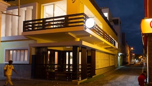 Un edificio de dos pisos con un balcón y un letrero iluminado.