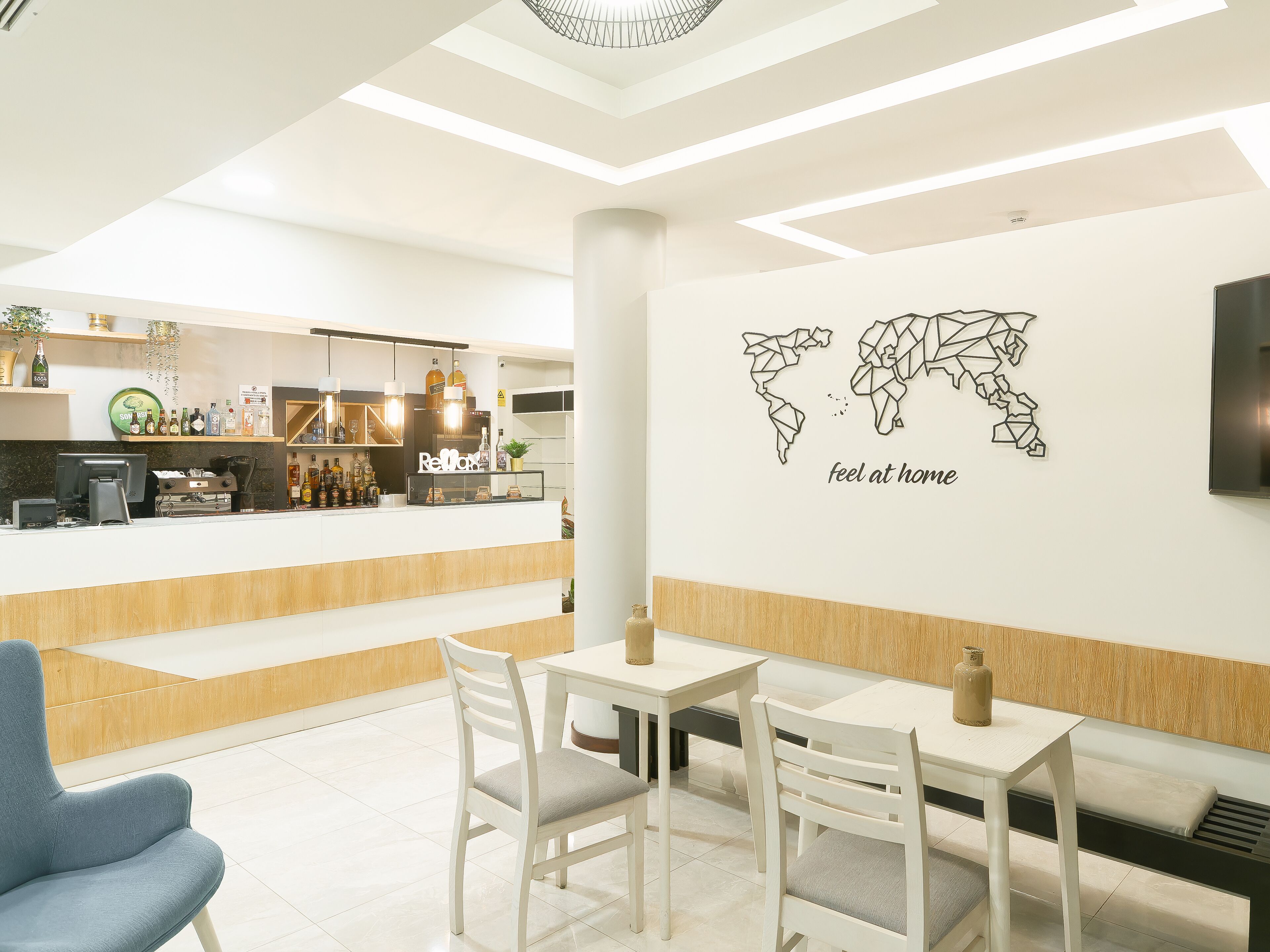 Un café moderno con zona de bar, asientos y una obra de arte en la pared.