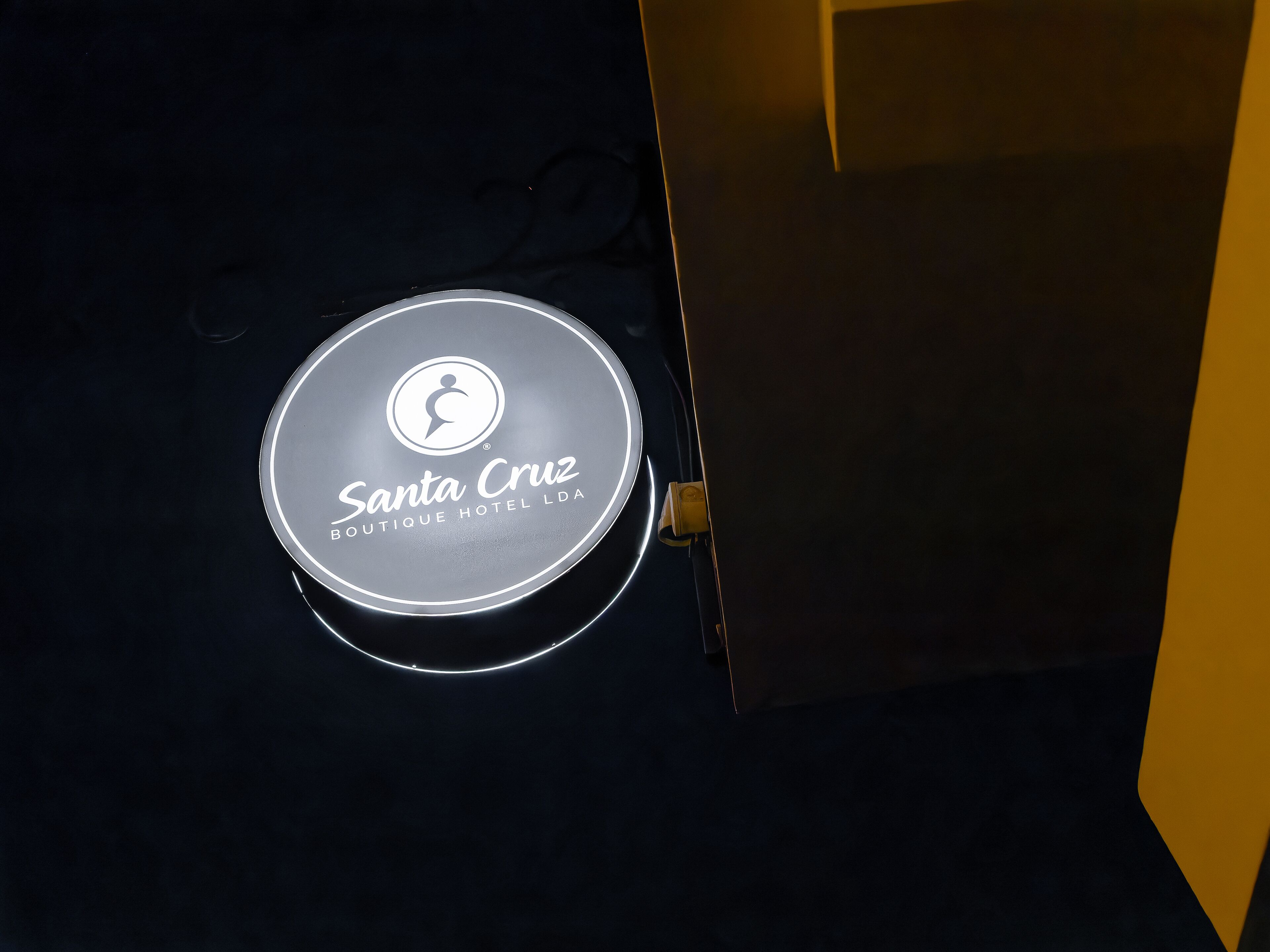 A circular sign with the text "Santa Cruz Boutique Hotel LDA" and a logo.