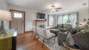 A living room with a fireplace, a sofa, a chair, and a television.