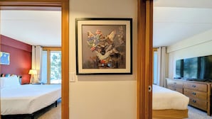 A hotel room with two beds, a TV, a painting, and a wooden dresser. - Keystone Lake Stay | King Beds + Summer Fun (Keystone)