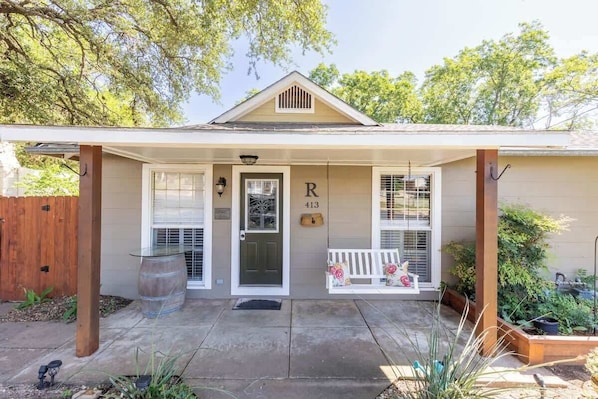 A single-story house with a covered porch, a front door, and a mailbox.