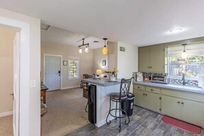 A kitchen with a central island, a sink, and a window.