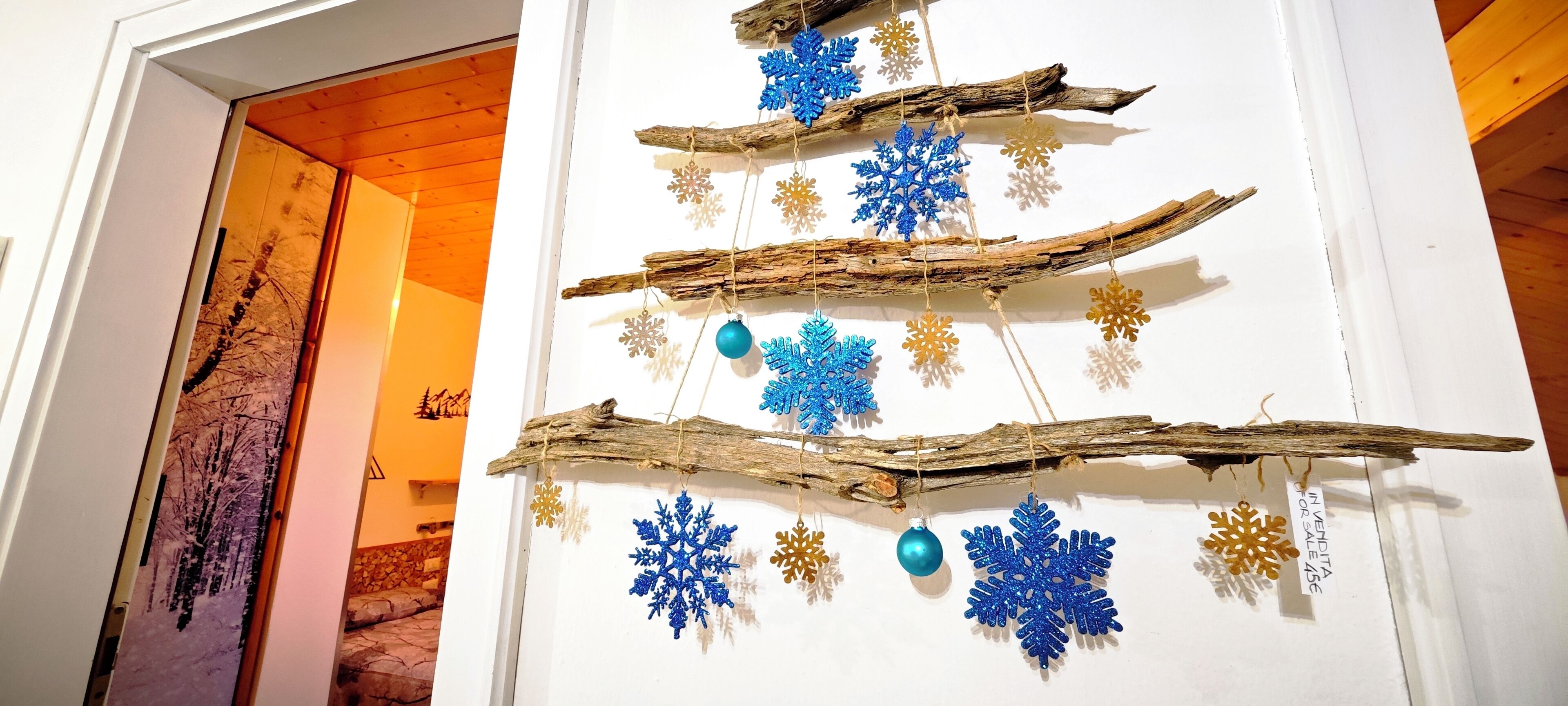 A wall with a rustic decoration made of branches and snowflake ornaments.