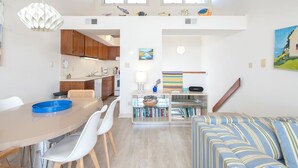 A modern, open-plan living space with a dining area, kitchen, and seating area.