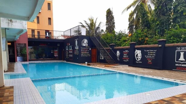 A swimming pool with a tiled deck, a staircase leading to a balcony, and a wall with informational text and a logo. - Mombasa County (Mombasa)