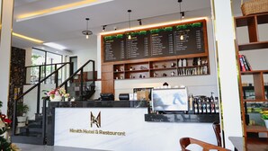 Eine Rezeption mit einer Marmor-Theke, einer Kaffeemaschine und einer Speisekarte.