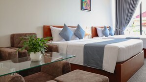 Ein Hotelzimmer mit einem Bett, einem Glastisch, einer Couch und einer Zimmerpflanze.