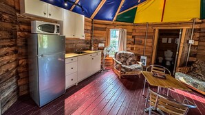 A compact kitchen with a refrigerator, microwave, and wooden cabinets. - Auberge du Vieux Moulin (Sainte-Emelie-de-L'Energie)