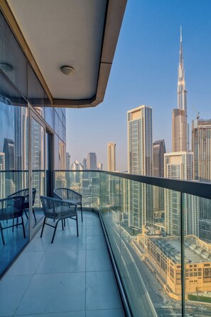 A balcony with a cityscape view, including a prominent skyscraper. - Stunning Burj Khalifa View Apartment in Downtown (Dubai)