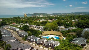A residential area with modern houses, a swimming pool, and a view of the sea. - 4BR Private Pool Villa in Jacó | Ciudad del Mar #158 (Jacó)
