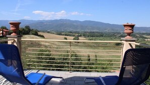 A balcony with a view of a mountainous landscape. - The Lime Tree (Castiglion Ubertini)