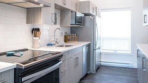 Una cocina moderna con electrodomésticos de acero inoxidable, lavavajillas y microondas.
