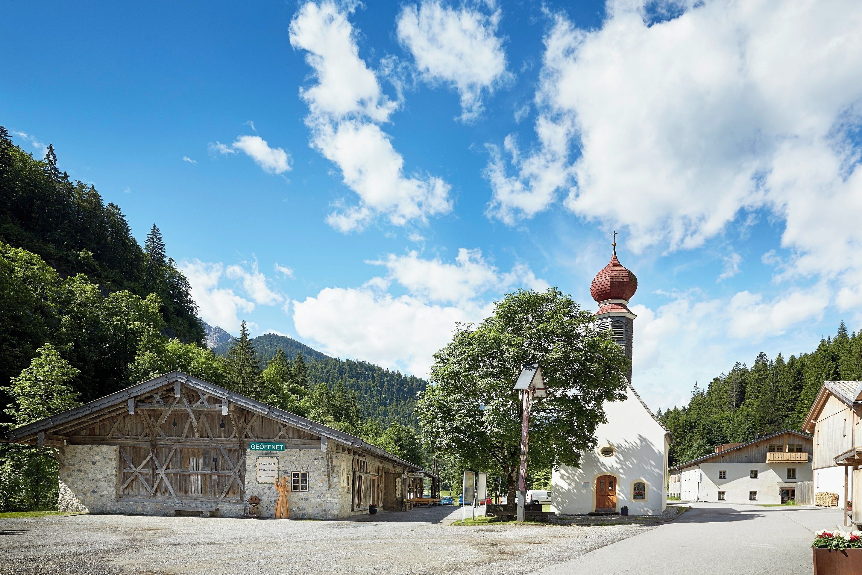 A rustic building with a stone facade and a wooden structure to the left.