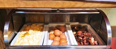 En buffé med äggröra, kokta ägg och bacon.