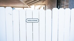 Ein weißer Zaun mit einem 'WELCOME'-Schild.