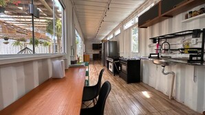A kitchen with a wooden countertop, black chairs, a stove, and a sink. - Villela Stay - Villa Kubitschek - Country house Lago Sul Brasília-DF (Lago Sul)