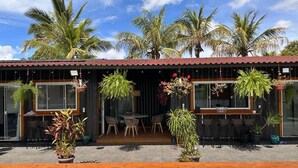 A poolside area with a wooden deck, outdoor seating, and potted plants. - Villela Stay - Villa Kubitschek - Country house Lago Sul Brasília-DF (Lago Sul)