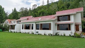 A modern two-story house with a red roof, white walls, and large windows. - Orania by Atsar (Srinagar)