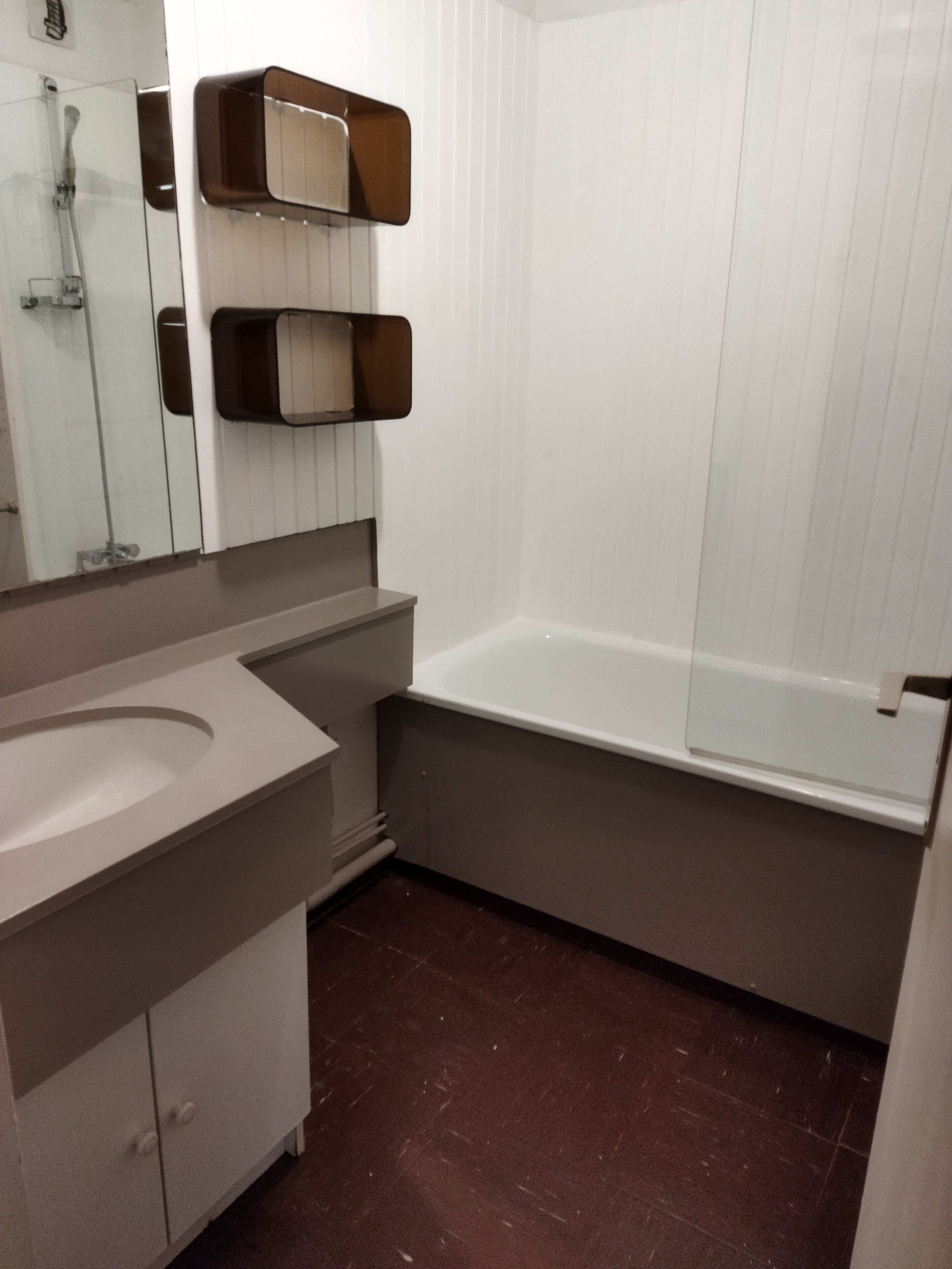 Ein Badezimmer mit weißem Waschbecken, einer Badewanne und einem Spiegel.