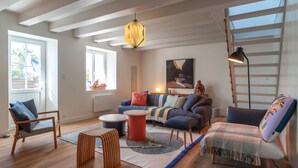 A modern living room with a sofa, chairs, a coffee table, and a rug.