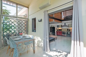 Enjoy meals for two in a dining area with a table set and kitchenette.