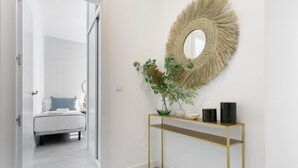 Ein modernes Schlafzimmer mit einem Bett, einem Nachttisch und einer Ablage mit dekorativen Accessoires.