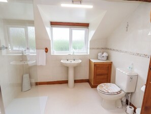 A bathroom with a sink, vanity, toilet, and a window. - 91 Main Street (Frodsham)