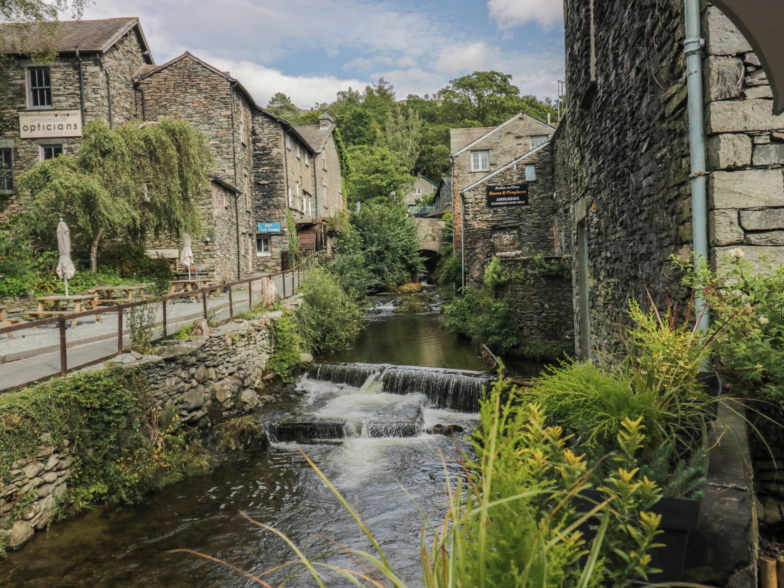 A stone building with a sign for 'Ambleside Opticians'.