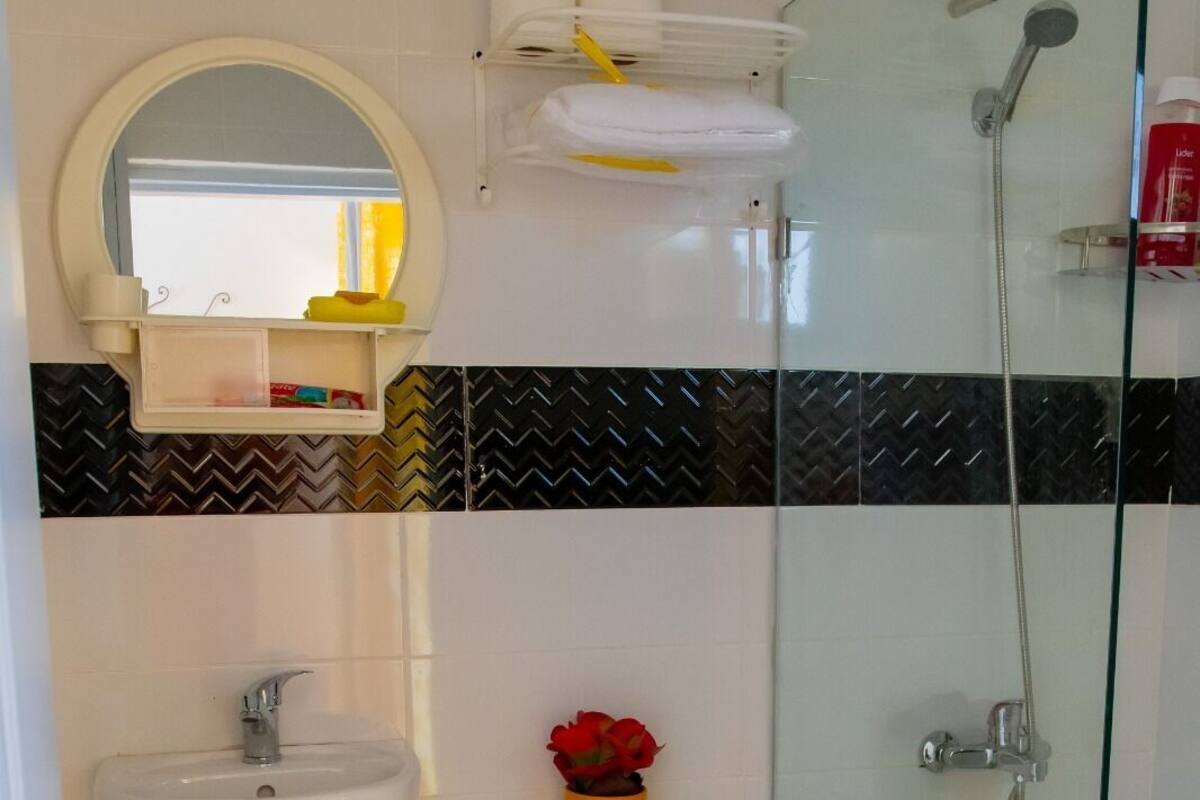A bathroom with a toilet, sink, and shower.