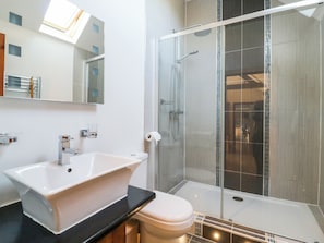 Un baño moderno con una bañera independiente, una ducha con mampara de vidrio y un inodoro.