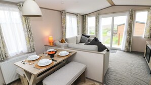Un espacio habitable compacto con comedor, sofá y vistas al exterior.