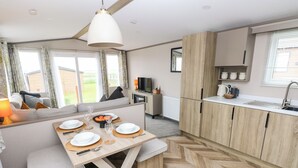 Una cocina moderna con comedor, armarios de madera y suelo con estampado de espiga.