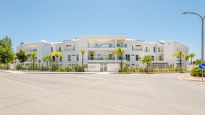 Un edificio moderno a più piani con tetto piatto, ampie finestre e una scala centrale.