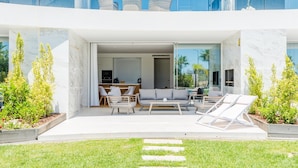 Una casa moderna con patio, mobili da esterno e vista sulla campagna circostante.