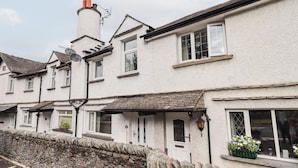 A row of white buildings with stone walls, a chimney, and a small garden. - 6 Calgarth View (Windermere)