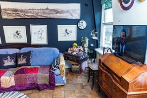 A cozy room with a bed, a dresser, a clock, and framed pictures on the wall. - 1 Bed Flat - Sleeps 2 - Wifi - Smoking (London)