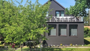 A modern two-story building with a balcony and large windows.