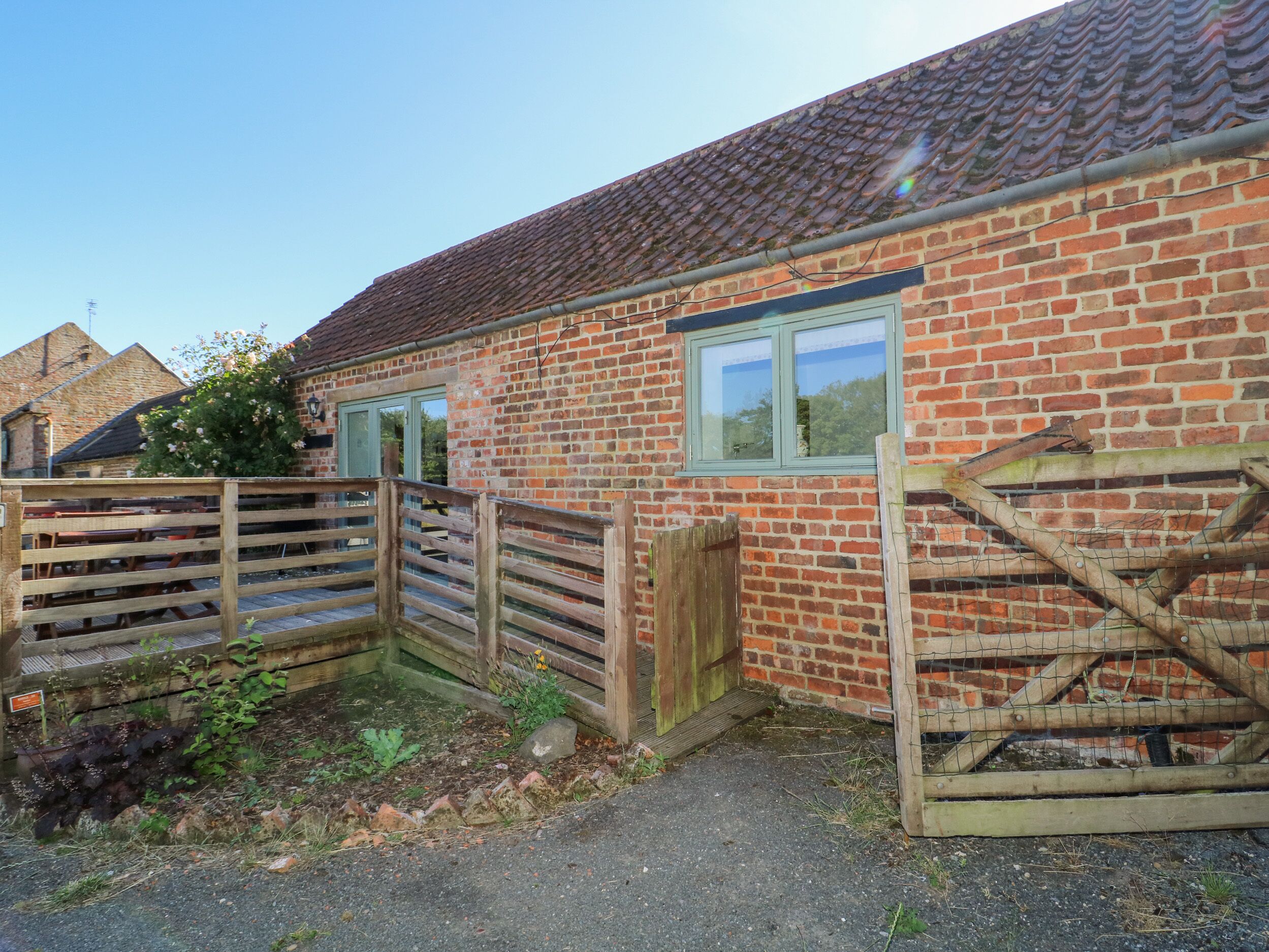 A brick building with a wooden gate, a window, and a brick wall.