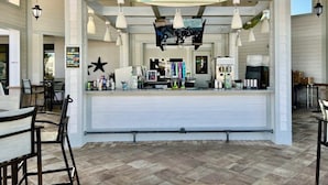 A restaurant with a counter, hanging lights, and a menu board. - Beautiful Pool Villa With Spa And Game Room-2730bd 5 Bedroom Home by RedAwning (Kissimmee)