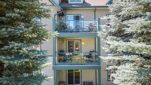 A two-story building with a balcony on the upper floor and a sliding glass door entrance. - Alpine Retreat | Pool | Hot Tub | Affordable (Radium Hot Springs)
