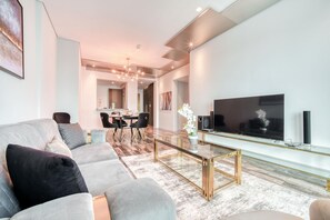 Un salon moderne comprenant un canapé, une table basse, un téléviseur et un coin repas.