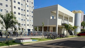 Un bâtiment moderne doté d’un toit plat, de grandes fenêtres et d’un espace de stationnement où l’on peut garer des vélos.