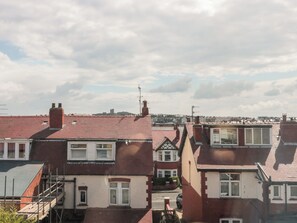 A row of terraced houses with red tiled roofs and white window frames.