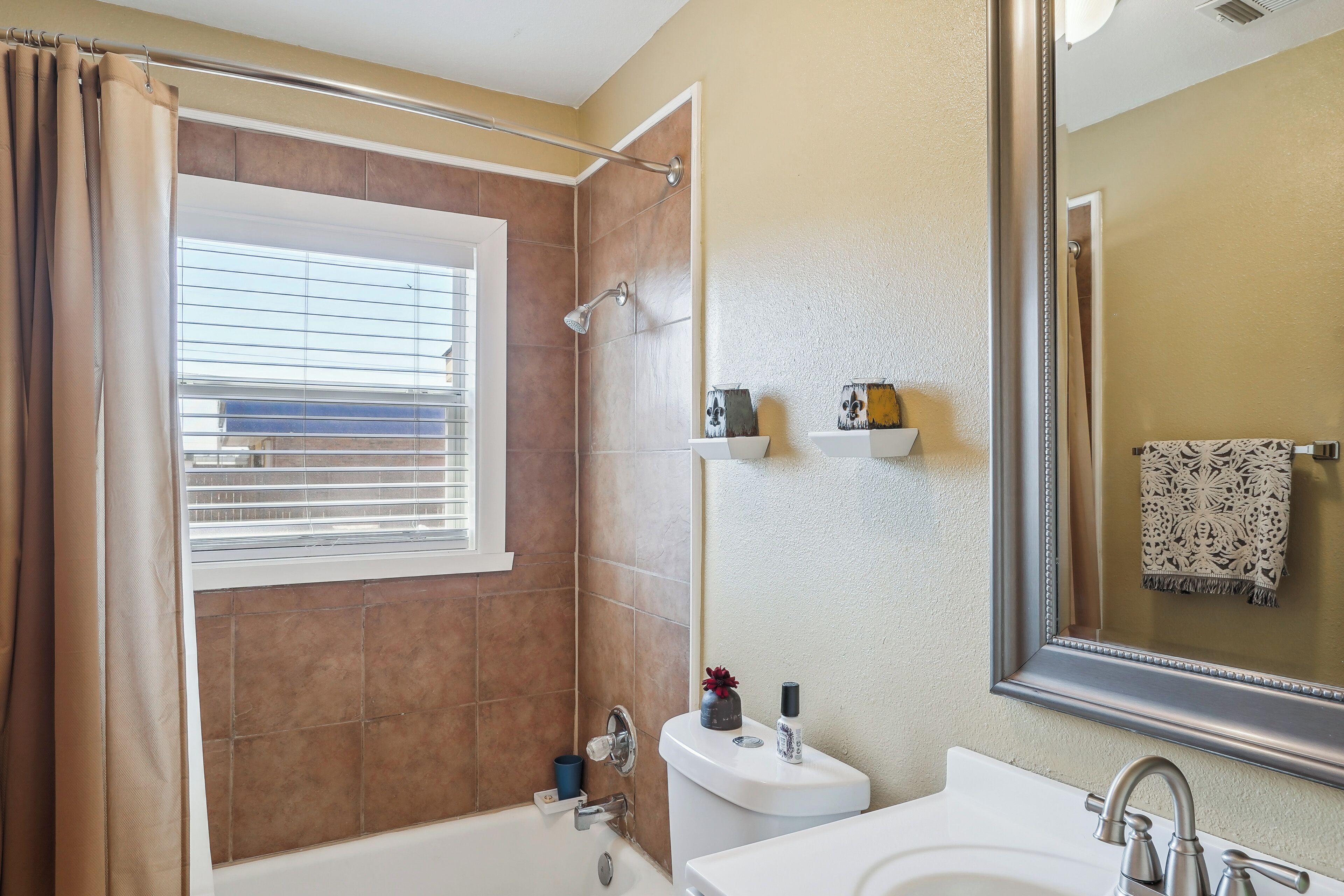 Une salle de bain avec une baignoire, une douche, un lavabo et un miroir.