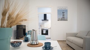 A modern living room with a sofa, a coffee table, and a kitchen in the background. - Passetto De Lectis in Ortona (Ortona)